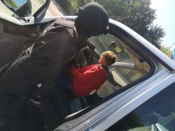 policjant grupy realizacyjnej przy radiowozie z dzieckiem