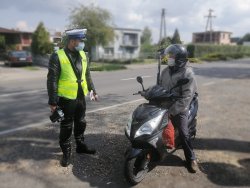 Policjant przeprowadza kontrolę drogową motocyklisty