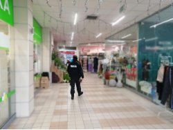 Na fotografii policjant kontrolujący wnętrze galerii handlowej