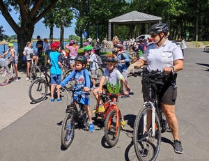 dzieci na rowerach z policjantką na rowerze