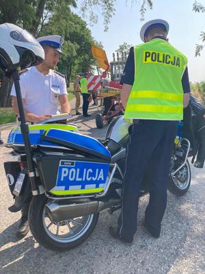 dwóch funkcjonariuszy policji stojących przy motocyklu