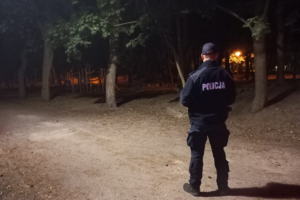 policjant stojący plecami do zdjęcia w porze nocnej w parku