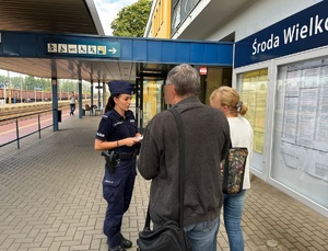 Policjantka rozmawiająca z dwiema osobami na PKP.