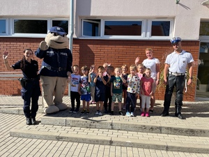 grupa dzieci z policjantami i maskotką sierżanta pyrka