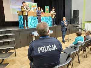 na scenie 3 osoby i plecami siedzący policjant