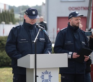 Zdjęcie ukazuje stojącego przy mównicy Komendanta Powiatowego Policji w Środzie Wlkp. insp. Paweł Wawrzyniak, obok Komendanta stoi lektor uroczystości.