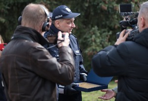 Na zdjęciu Komendant Wojewódzki Policji w Poznaniu nadinsp. Piotr Mąka przekazujący symboliczny klucz do otwarcia Posterunku Policji w Zaniemyślu oraz dwóch fotoreporterów.