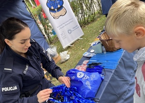 policjantka stojaca z dzieckiem przy smyczach