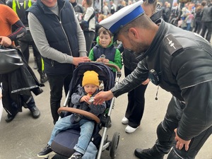 policjant dający dziecku odblask