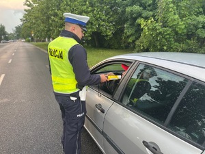 policjant kontrolujący stan trzeźwości kierowcy