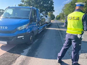 policjant idący obok zespołu pojazdów