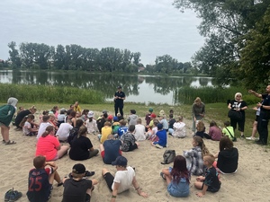 grupa dzieci słuchające policjantki