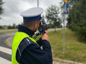 stojący policjant z miernikiem prędkości