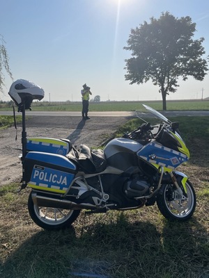 policjant mierzący prędkość, z przodu motocykl