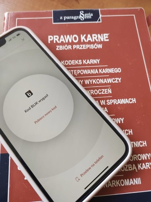 telefon komórkowy leżący na kodeksie karnym