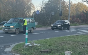 policjant stojący przy samochodzie osobowym